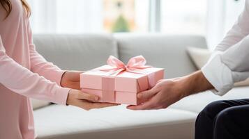 bijgesneden schot van Mens geven geschenk doos naar vrouw in leven kamer foto