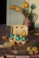Pasen nog steeds leven, amandelen in wit chocola en groen Pasen eieren geel tulpen foto
