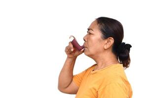 vrouw senior geduldig toepassingen bruin astma inhalator voor Verlichting astma. concept, Gezondheid zorg Bij huis. farmaceutisch producten voor behandeling symptomen van astma of copd. gebruik onder voorschrift van dokter. foto