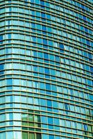 fragment van een modern kantoor gebouw. abstract meetkundig achtergrond. een deel van een wolkenkrabber met glas ramen. foto