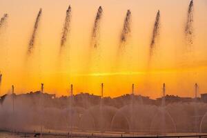 groot fonteinen Aan de kunstmatig vijver, verlichte door zonlicht Bij zonsondergang in Tasjkent stad park Bij zomer. foto