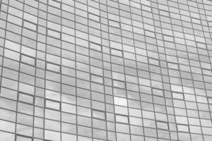 zwart en wit fragment van een modern kantoor gebouw. abstract meetkundig achtergrond. een deel van de facade van een wolkenkrabber met glas ramen. foto