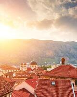 zonsondergang over- de rood betegeld daken van de oud stad- van kotor, Montenegro. foto