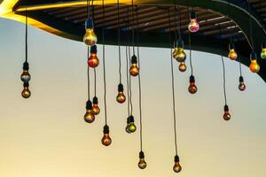 feestelijk hangende slingers met licht bollen tegen de achtergrond van een schemering lucht. foto