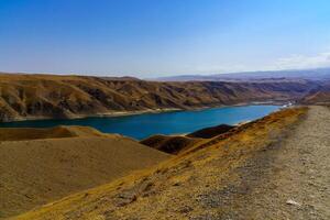 een uitgestorven een deel van de zaamin natuur reserveren in Oezbukistan Aan een zonnig zomer dag. visie van de bergen en reservoir. foto