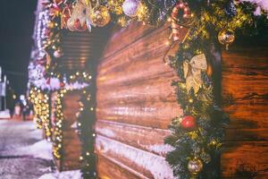 Kerstmis of nieuw jaar markt in een Europa met huizen versierd met speelgoed- ballen en slingers Bij nacht. wijnoogst film stijlvol. foto