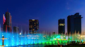 Oezbekistan, Tasjkent - september 29, 2023 een fontein met laser verlichting en licht muziek- in Tasjkent stad park Bij 's nachts en wolkenkrabbers. foto