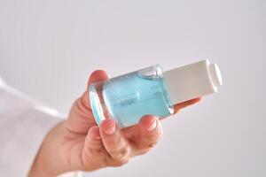 blauw serum met pipet in een dames handen in een gewaad. foto