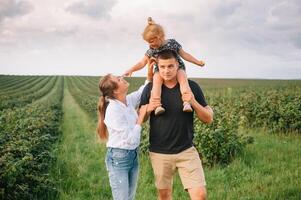 gelukkig familie met weinig dochter uitgeven tijd samen in zonnig veld. foto