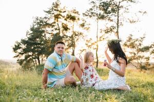 gelukkig familie concept - vader, moeder en kind dochter hebben pret en spelen in natuur foto