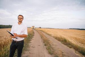 jong boer ingenieur staand Aan tarwe veld- foto