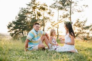 gelukkig familie concept - vader, moeder en kind dochter hebben pret en spelen in natuur foto