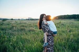 stil moeder en knap zoon hebben pret Aan de natuur. gelukkig familie concept. schoonheid natuur tafereel met familie buitenshuis levensstijl. gelukkig familie resting samen. geluk in familie leven. moeders dag foto