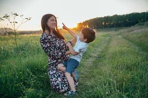 stil moeder en knap zoon hebben pret Aan de natuur. gelukkig familie concept. schoonheid natuur tafereel met familie buitenshuis levensstijl. gelukkig familie resting samen. geluk in familie leven. moeders dag foto