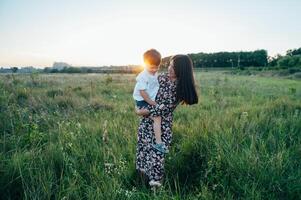 stil moeder en knap zoon hebben pret Aan de natuur. gelukkig familie concept. schoonheid natuur tafereel met familie buitenshuis levensstijl. gelukkig familie resting samen. geluk in familie leven. moeders dag foto