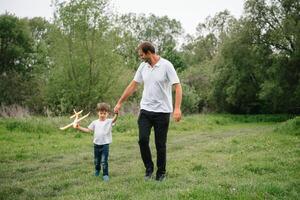 vader en zoon spelen in vliegenier. superman vader en zoon hebben plezier. verbeelding en dromen van wezen een piloot. kind piloot met vliegtuig Aan vaders rug. reizen en vakantie in zomer. vrijheid. foto