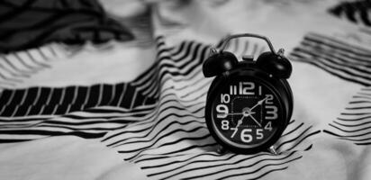 deadline en tijd beheer concept. zwart retro alarm klok Aan bed. tijd naar wakker worden omhoog voor de ochtend- routine- foto