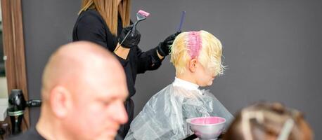 kleur vrouw haar- in de haar- salon. jong vrouw hebben haar haar- geverfd door schoonheidsspecialist Bij de schoonheid salon. foto