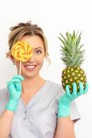 mooi glimlachen schoonheidsspecialist Holding vers ananas en Hoes haar oog met lolly over- wit achtergrond. huidsverzorging reiniging eco biologisch. foto