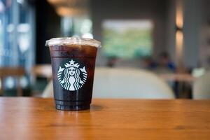 Bangkok, Thailand - april 12, 2024 starbucks koffie bevroren americano koffie drank Aan hout tafel. foto