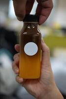 americano oranje sap drank in plastic fles met twee hand- iemand foto