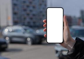 hand- Holding mobiel telefoon scherm bespotten omhoog, stad achtergrond, auto, gebouw foto