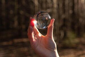 glas transparant wereldbol, gebied, bal in hand- in natuur. visie concept foto