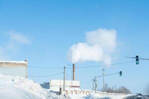 rook van de schoorsteen van verwerken gevaarlijk materialen Bij de fabriek. vrijlating van schadelijk stoffen in de lucht van de pijp in winter foto