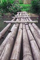 een oude bamboe brug verbonden naar kruis de kanaal rivier. foto