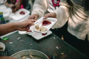 van hand- naar hand. sharing voedsel met dakloos foto