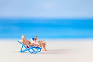 miniatuur mensen , paar ontspannende Aan strand stoelen Aan de strand foto