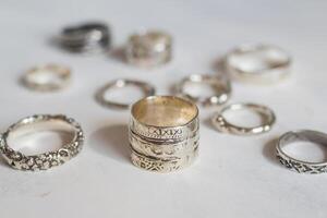 zilver sieraden Aan een zacht wit achtergrond. handgemaakt elegant zilver ringen. foto