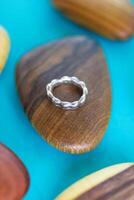 getextureerde zilver ring Aan een houten houder en blauw achtergrond. handgemaakt kostbaar item. sieraden accessoires. foto