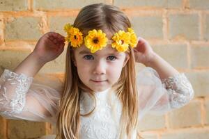 portret van een meisje met lang gekruld haar- en een geel bloem kroon in een natuurlijk instelling. foto