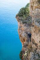 antalya, kalkoen - november 26, 2022. onherkenbaar Mens staand Aan klif, op zoek naar de blauw zee. foto