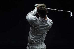 golfspeler in wit overhemd swinging Aan zwart achtergrond. foto