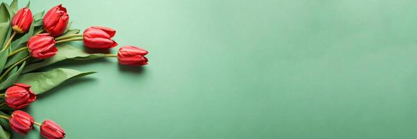 mooi rood tulpen in ambacht papier Aan groen pastel achtergrond met kopiëren ruimte, voorjaar tijd, moeder dag foto