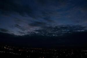 hemel bewolkt lucht dag avond schemer tijd met zonlicht straal van tussen wolken met stad stad- achtergrond foto