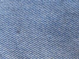dichtbij omhoog van een blauw jeans kleding stof structuur achtergrond foto