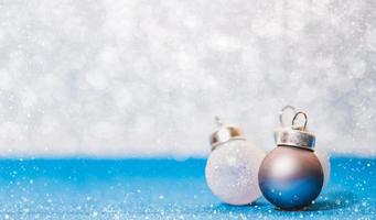 kerstbal op levendige blauwe glittervloer en witte bokehvervaging foto
