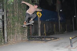 Indonesië - medan 01 augustus 2023 een Aziatisch Mens aan het doen skateboard trucs Aan een oprit foto