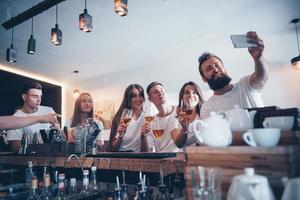 vrije tijd en communicatie concept. groep gelukkige lachende vrienden genieten van drankjes en praten in de bar of pub foto