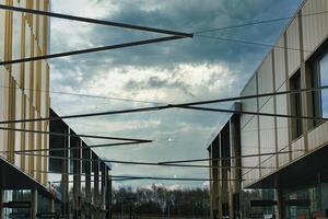 modern architectuur met meetkundig metaal structuren tegen een dramatisch bewolkt lucht, presentatie van hedendaags stedelijk ontwerp en Open ruimtes. foto