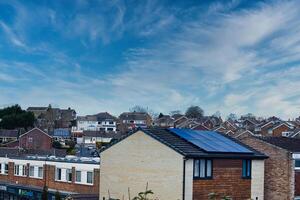 buitenwijk landschap met woon- huizen met zonne- panelen onder een dynamisch blauw lucht met piekerig wolken, presentatie van duurzame leven in een modern buurt in harrogeren, noorden yorkshire. foto