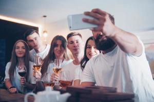 vrije tijd en communicatie concept. groep gelukkige lachende vrienden genieten van drankjes en praten in de bar of pub foto