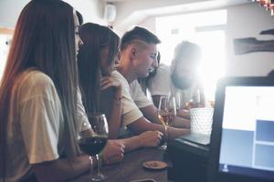 vrije tijd en communicatie concept. groep gelukkige lachende vrienden genieten van drankjes en praten in de bar of pub foto