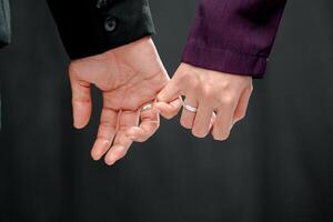 bruiloft ring foto schieten concept een Mens vervelend een formeel zwart pak en Purper stropdas en vrouw met Purper pak is Holding een bruiloft ring