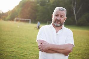 een oudere man lacht en is gelukkig in de natuur foto