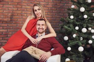 jong koppel ontmoeten kerst knuffelen thuis. Nieuwjaar. feeststemming van een man en een vrouw foto