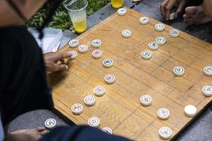 Ho chi minh, vietnam, 22 februari 2017 - niet-geïdentificeerde man die traditioneel Chinees schaak speelt op de stoep van ho chi minh in vietnam. het is een van de meest populaire bordspellen in China. foto